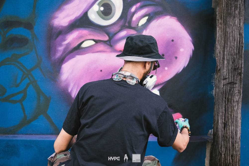 Artist painting a character mural